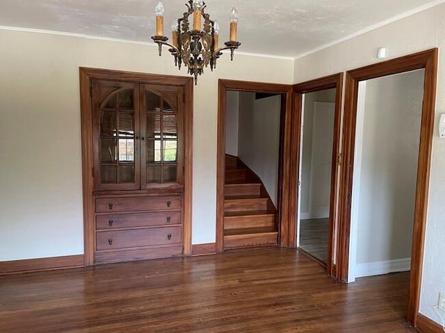 interior space featuring dark hardwood / wood-style floors, an inviting chandelier, and crown molding