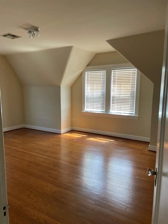 additional living space featuring light hardwood / wood-style flooring and vaulted ceiling