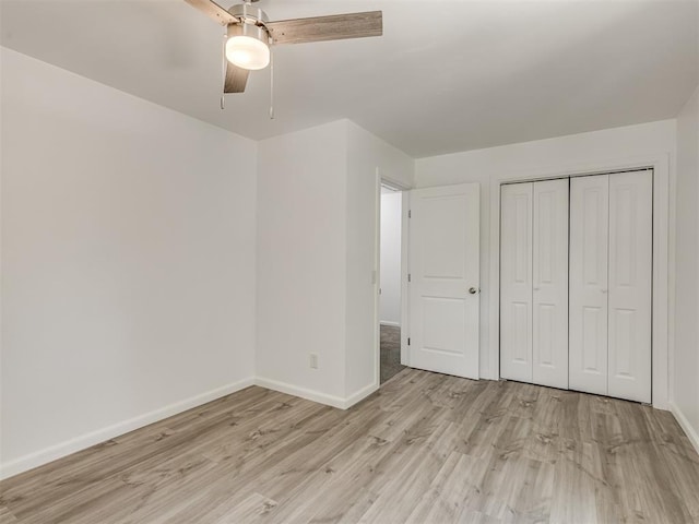 unfurnished bedroom with ceiling fan, light hardwood / wood-style flooring, and a closet