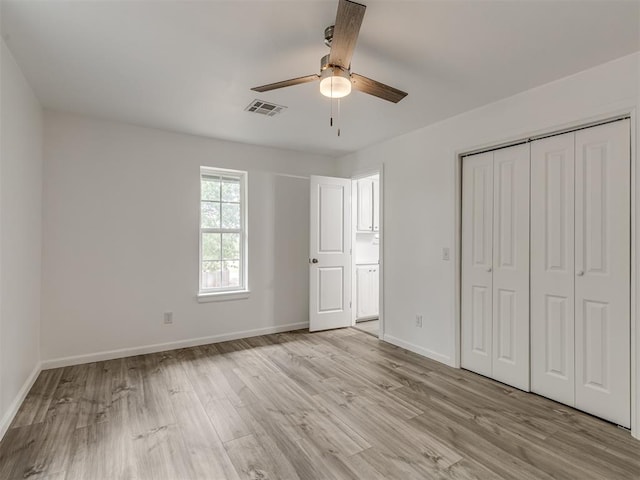 unfurnished bedroom featuring a closet, light hardwood / wood-style floors, and ceiling fan