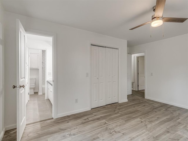 unfurnished bedroom with a closet, light hardwood / wood-style floors, ceiling fan, and connected bathroom