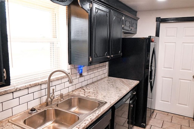 kitchen with decorative backsplash, light stone countertops, sink, light tile patterned floors, and dishwasher