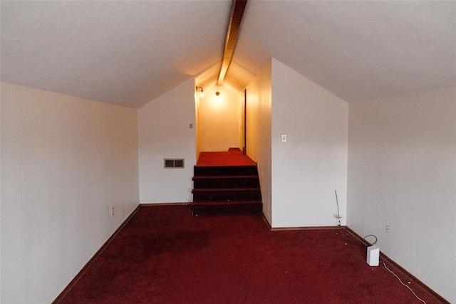 additional living space featuring vaulted ceiling with beams and dark carpet