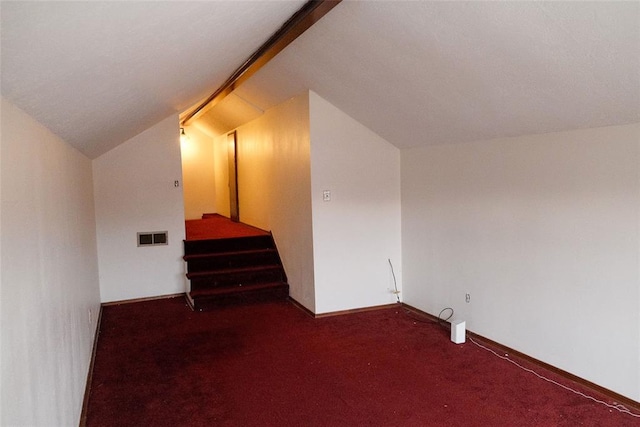 additional living space with lofted ceiling and dark colored carpet