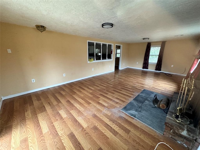 unfurnished living room featuring hardwood / wood-style floors and a textured ceiling