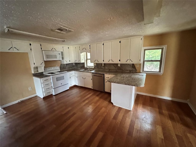 kitchen with kitchen peninsula, a textured ceiling, white appliances, dark hardwood / wood-style floors, and white cabinetry