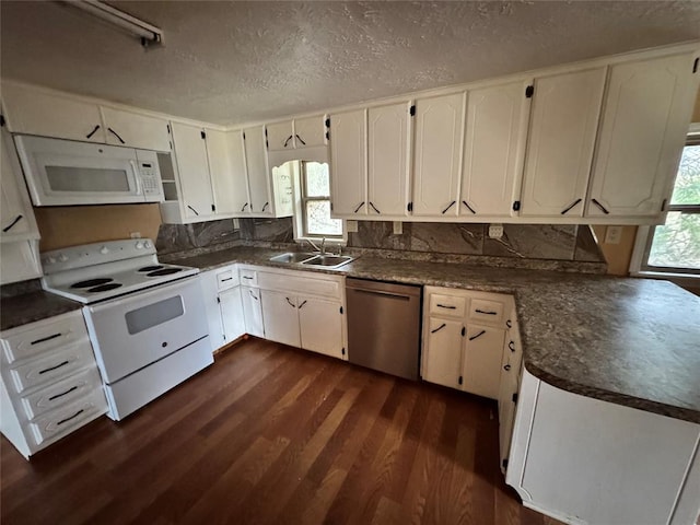 kitchen with dark hardwood / wood-style floors, a healthy amount of sunlight, white appliances, and sink