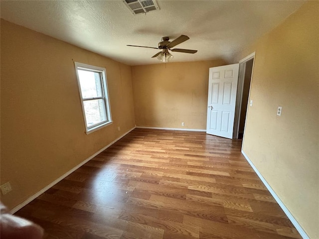 unfurnished room featuring a textured ceiling, light hardwood / wood-style flooring, and ceiling fan