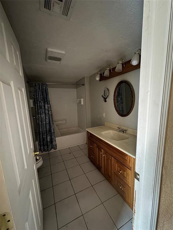 full bathroom with shower / bath combination with curtain, vanity, a textured ceiling, tile patterned flooring, and toilet