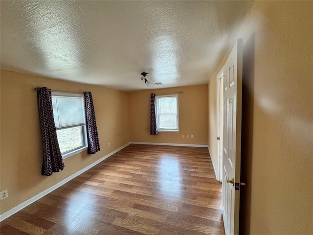 unfurnished room featuring hardwood / wood-style floors and a textured ceiling