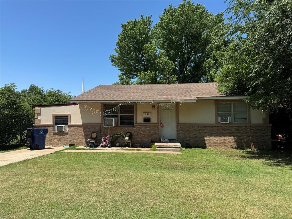 view of front of home featuring cooling unit and a front lawn