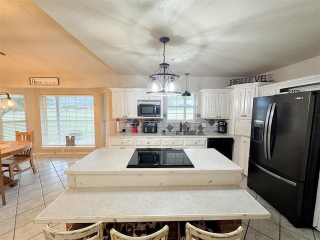 kitchen with black appliances, decorative backsplash, a kitchen island, and white cabinetry