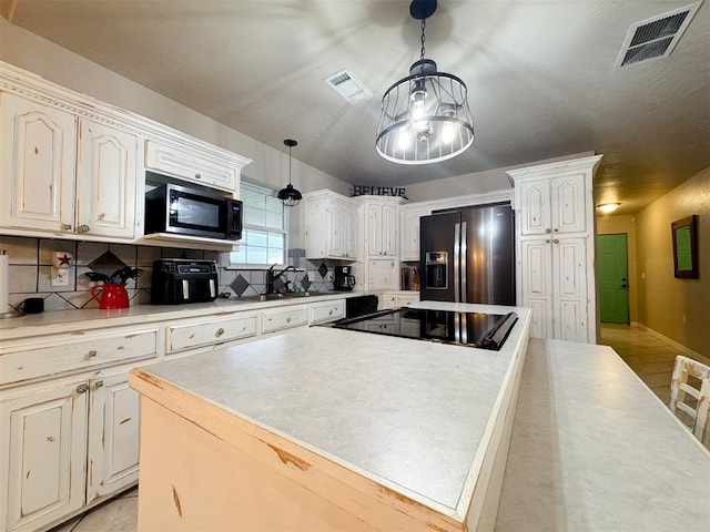 kitchen featuring backsplash, pendant lighting, white cabinets, and black appliances