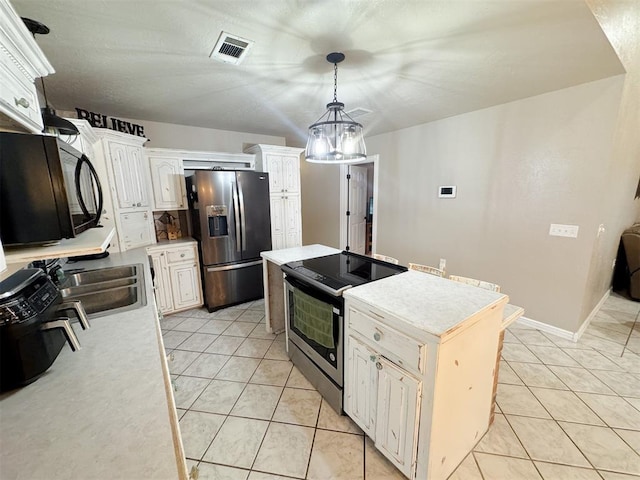 kitchen with stainless steel appliances, decorative light fixtures, a notable chandelier, white cabinets, and a kitchen island