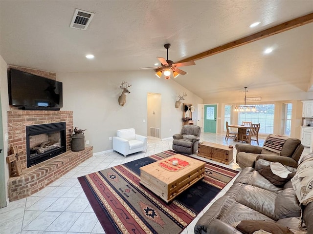 tiled living room featuring ceiling fan with notable chandelier, a textured ceiling, vaulted ceiling with beams, and a fireplace