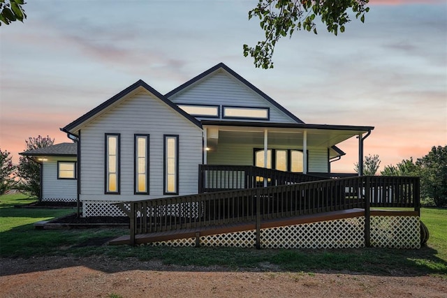 back house at dusk with a deck