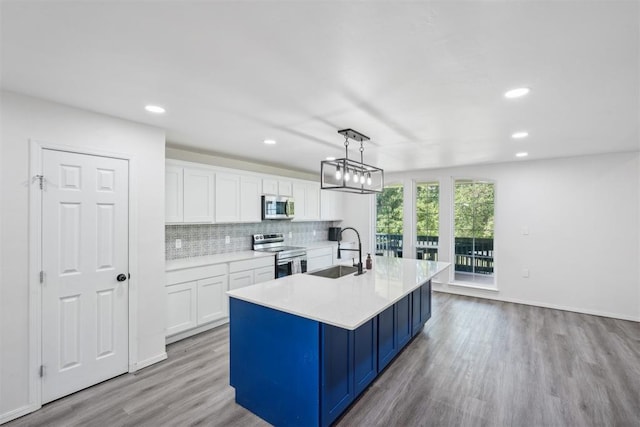 kitchen with decorative light fixtures, light hardwood / wood-style floors, sink, and appliances with stainless steel finishes