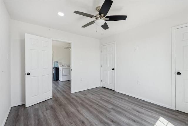 unfurnished bedroom with dark hardwood / wood-style flooring, ceiling fan, and washing machine and dryer