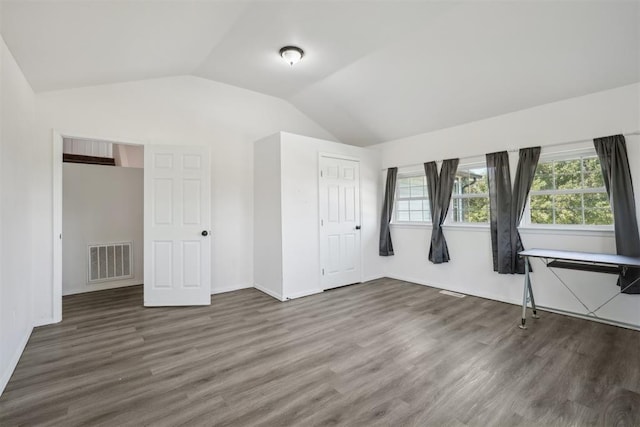 unfurnished bedroom featuring a closet, dark hardwood / wood-style flooring, and vaulted ceiling