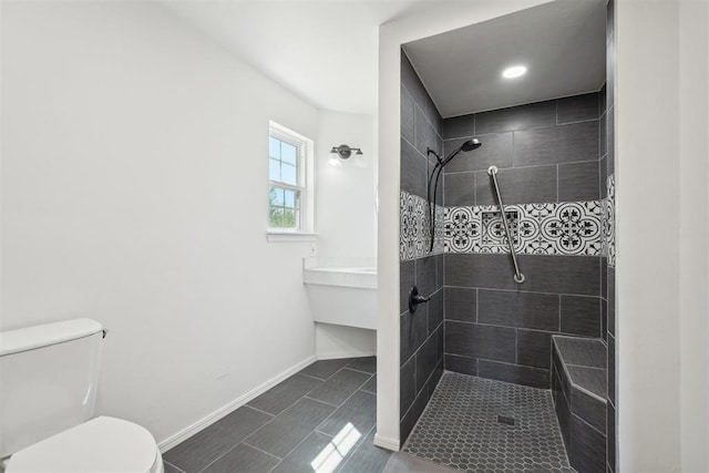 bathroom featuring tiled shower and toilet