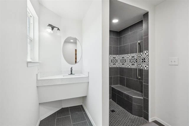 bathroom featuring tile patterned flooring, vanity, and tiled shower