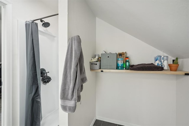 bathroom featuring a shower with curtain and lofted ceiling