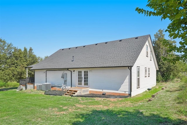 back of property with a yard, central air condition unit, and french doors