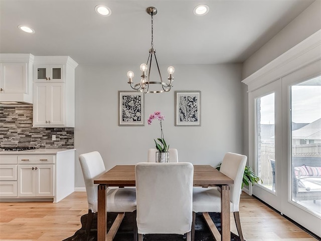 dining space featuring an inviting chandelier, light hardwood / wood-style flooring, and a healthy amount of sunlight