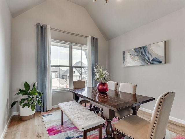 dining room with lofted ceiling and light wood-type flooring