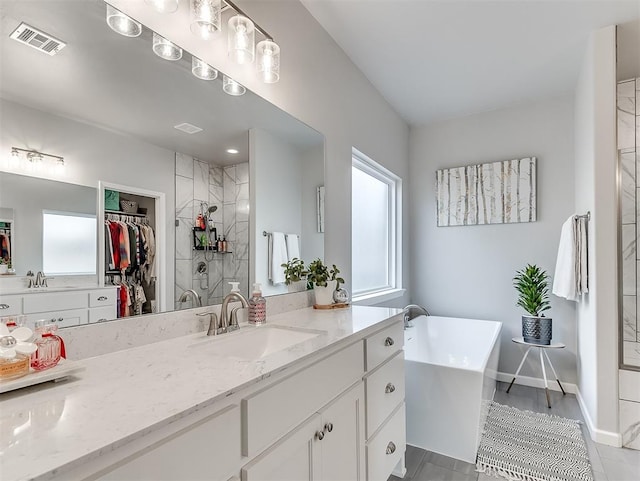 bathroom with tile patterned floors, vanity, a healthy amount of sunlight, and separate shower and tub