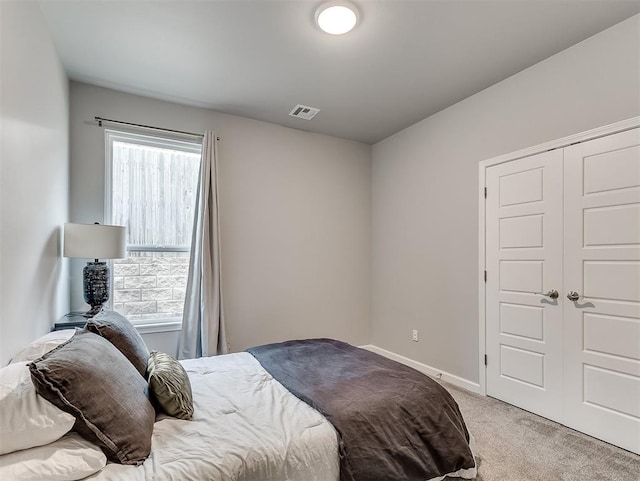 bedroom with a closet and light colored carpet