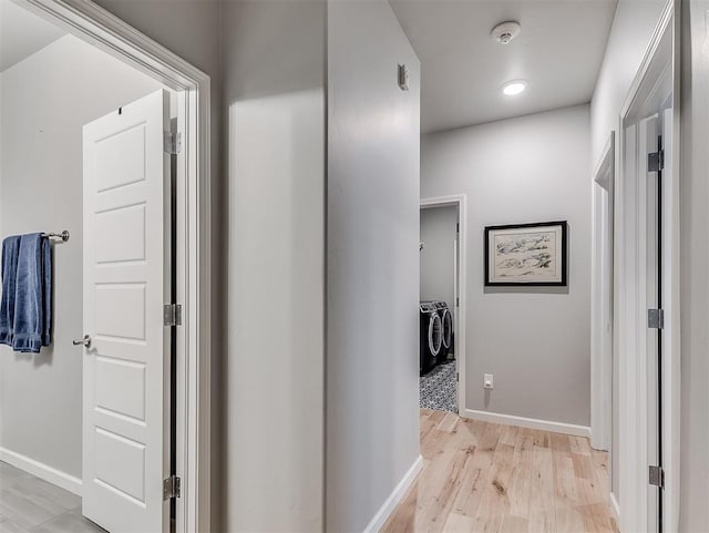 corridor featuring washer and clothes dryer and light hardwood / wood-style floors