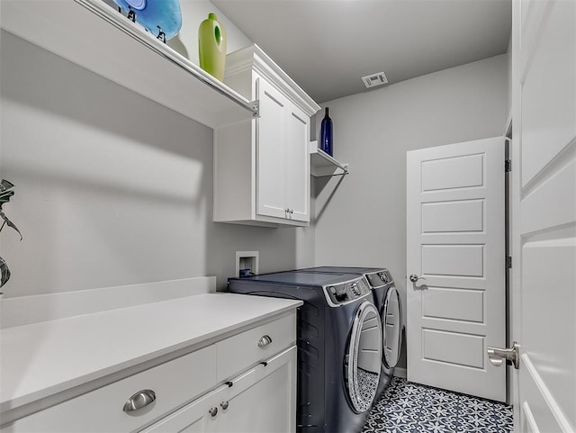 washroom with washing machine and dryer and cabinets