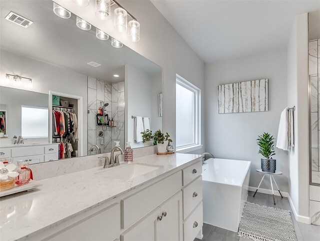 8216 Crew Ln, Edmond, OK 73034 - full bath featuring vanity, a freestanding bath, a walk in closet, and a tile shower