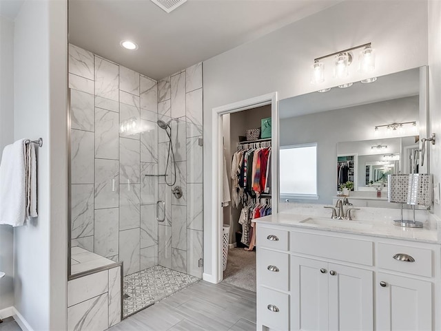 8216 Crew Ln, Edmond, OK 73034 - bathroom with a shower stall, vanity, a walk in closet, and recessed lighting