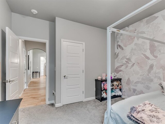 8216 Crew Ln, Edmond, OK 73034 - bedroom featuring light carpet and arched walkways