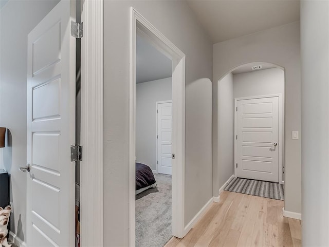 8216 Crew Ln, Edmond, OK 73034 - hall featuring light wood finished floors and arched walkways