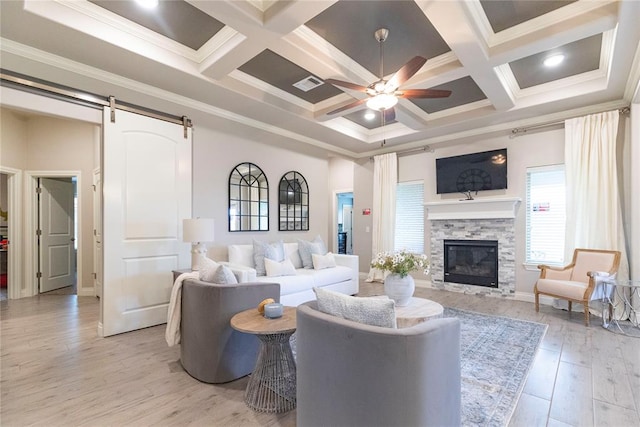 living room with beam ceiling, a barn door, light hardwood / wood-style floors, and coffered ceiling