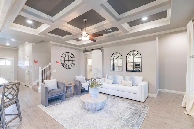 living room with coffered ceiling, a barn door, light wood-type flooring, ornamental molding, and beamed ceiling