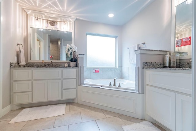 bathroom with a tub, tile patterned flooring, and vanity