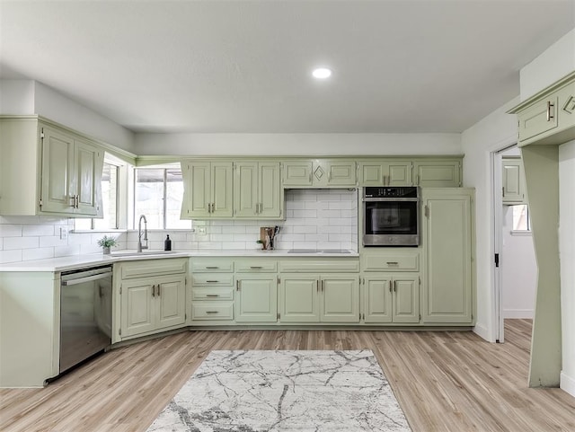 kitchen featuring light wood-type flooring, sink, appliances with stainless steel finishes, and green cabinetry