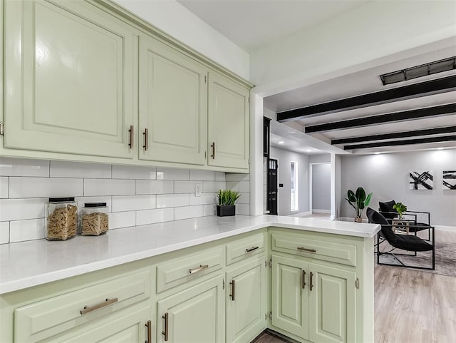 kitchen featuring light hardwood / wood-style floors, beam ceiling, kitchen peninsula, and tasteful backsplash