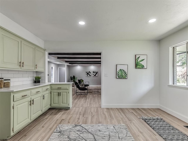 kitchen with decorative backsplash, green cabinets, light wood-type flooring, and beam ceiling