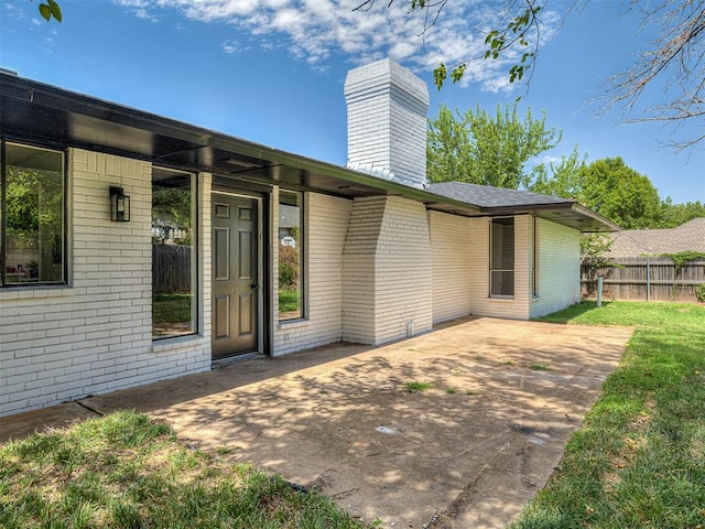 view of exterior entry with a patio