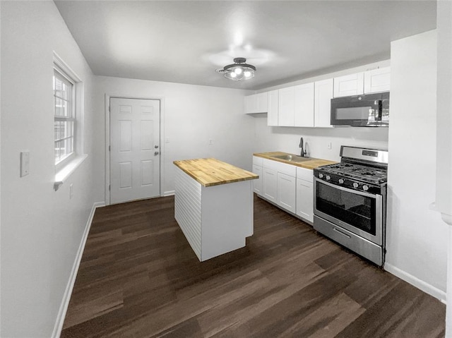 kitchen featuring wooden counters, dark hardwood / wood-style flooring, white cabinetry, and stainless steel gas range