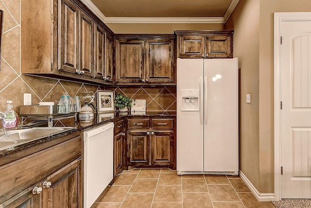 kitchen featuring decorative backsplash, ornamental molding, dark stone counters, white appliances, and light tile patterned flooring