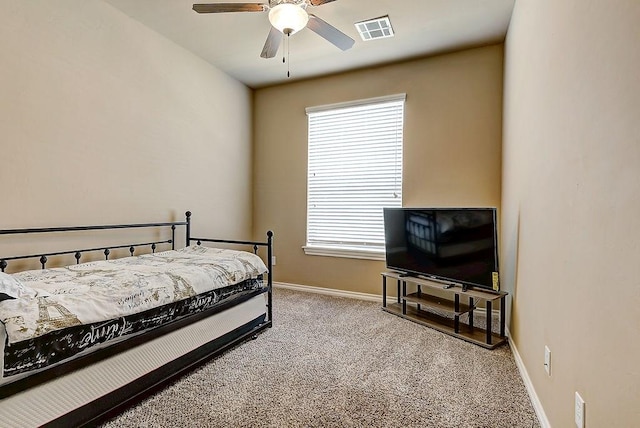 carpeted bedroom with ceiling fan and multiple windows