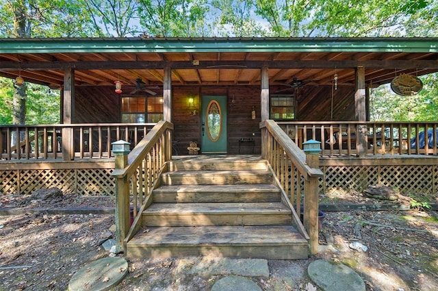 view of exterior entry with ceiling fan and a porch