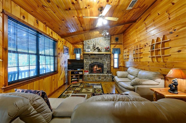 living room with wood-type flooring, vaulted ceiling, ceiling fan, and wood walls