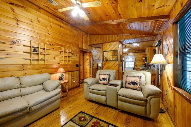 cinema room featuring light hardwood / wood-style floors, plenty of natural light, wooden walls, and ceiling fan